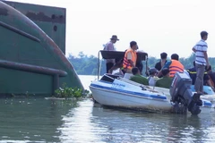 Các lực lượng chức năng đang phối hợp tìm kiếm thi thể nạn nhân mất tích dưới sông Đồng Nai. (Ảnh: Nguyễn Văn Việt/TTXVN)