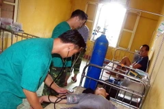 Lực lượng quân y đảo Phan Vinh cấp cứu cho ngư dân. (Ảnh: TTXVN phát)