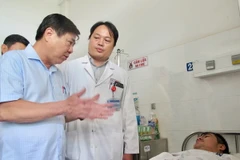 Chủ tịch Ủy ban nhân dân TP.Hồ Chí Minh Nguyễn Thành Phong thăm “hiệp sỹ” Nguyễn Đức Huy tại Bệnh viện Thống Nhất. (Ảnh: Đinh Hằng/TTXVN)