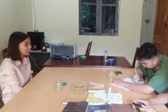 Đối tượng Nguyễn Thị Ánh Nguyệt cùng các tài liệu, vật dụng liên quan đến sinh hoạt, truyền đạo trái phép tại cơ quan chức năng. (Ảnh: Xuân Tiến/TTXVN)