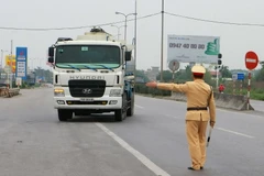 Kiểm tra xe quá khổ, quá tải lưu thông trên đường. (Ảnh: Doãn Tấn/TTXVN)
