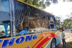 Một chiếc xe khách bị ném đá làm hư hỏng nặng. (Ảnh: Phạm Cường/TTXVN)