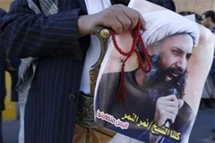 Người biểu tình cầm di ảnh của giáo sỹ Nimr al-Nimr. (Nguồn: Reuters)
