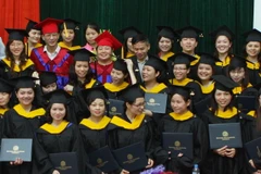 Các tân thạc sỹ Trường Đại học Ngoại ngữ - Đại học Quốc gia Hà Nội nhận bằng tốt nghiệp. (Ảnh: Bích Ngọc/TTXVN)