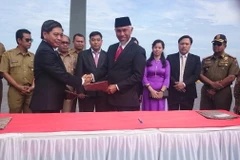 Lãnh đạo hai địa phương ký bản ghi nhớ. (Ảnh: Minh Cừ/Vietnam+)