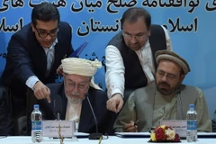 Chủ tịch Hội đồng Hòa bình tối cao Afghanistan Pir Sayed Ahmed Gailani (trái, trước) và đại diện của thủ lĩnh Gulbuddin Hekmatyar, ông Amin Karim (phải) sau lễ ký thỏa thuận hòa bình ở Kabul ngày 22/9. (Nguồn: AFP/TTXVN)