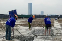 Công nhân Công ty Cổ phần Tập đoàn Phương Bắc dùng máy khoan phá dỡ phần trần bê tông. (Ảnh: Minh Nghĩa/TTXVN)