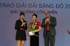 Ban tổ chức trao giải thưởng cá nhân có những đóng góp tích cực trong hỗ trợ những người trong Mạng lưới người sống chung với HIV Việt Nam. (Ảnh: Phương Vy/TTXVN)