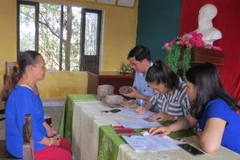 Người dân xã Lộc Điền chuẩn bị nhận tiền bồi thường. (Ảnh: Tường Vi/TTXVN)