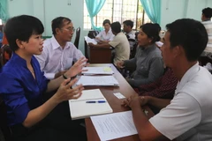 Các luật sư giúp hộ dân tiến hành các thủ tục pháp lý. (Ảnh: Mạnh Dương/TTXVN)