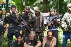 Phiến quân Abu Sayyaf và những con tin bị chúng bắt cóc. (Nguồn: TTXVN)