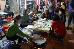 Du khách thưởng thức ẩm thực đêm tại chợ Đồng Văn. (Ảnh: Minh Quyết/TTXVN)