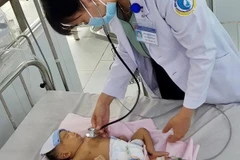 Bác sỹ thăm khám cho bệnh nhi sau phẫu thuật. (Ảnh: Thanh Sang/TTXVN)