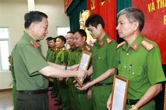 Đại tướng Tô Lâm, Bộ trưởng Bộ Công an trao tặng quyết định khen thưởng cho các tập thể, cá nhân có thành tích xuất sắc. (Ảnh: Doãn Tấn/TTXVN)
