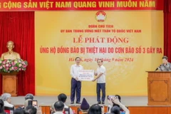 Phó Thống đốc Thường trực Đào Minh Tú trao ủng hộ của ngành Ngân hàng. (Ảnh: Vietnam+)