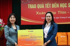 Đại diện SHB mang những món quà thiết thực nhằm kịp thời chia sẻ khó khăn với các em trong dịp Tết đến Xuân về. (Ảnh: Vietnam+)
