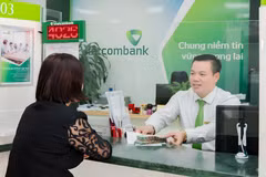 Giao dịch viên Lê Xuân Tiến tại phòng giao dịch Như Quỳnh Vietcombank Hưng Yên. (Ảnh: Vietnam+)
