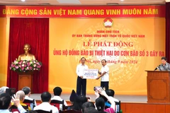 Đại diện ngành Ngân hàng, ông Đào Minh Tú - Phó Thống đốc Thường trực Ngân hàng Nhà nước trao số tiền 38,4 tỷ đồng tại lễ phát động của Ủy ban Mặt trận Tổ quốc Việt Nam để ủng hộ đồng bào bị thiệt hại do bão số 3. (Ảnh: Vietnam+)