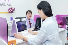 Khách hàng cập nhập khuôn mặt tại phòng giao dịch. (Ảnh: Vietnam+)