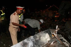 Hiện trường vụ tai nạn và lực lượng cứu hộ đang khẩn trương đưa thi thể các nạn nhân ra khỏi xe. (Ảnh Văn Sơn/TTXVN)