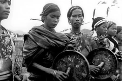 Người Bana dùng dùi mềm gõ vào lòng chiêng. (Một trong những bức ảnh tư liệu cũ)