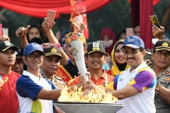 Thị trưởng thành phố Đông Jakarta, ông M. Anwar (phải) tham gia lễ tiếp đuốc. (Nguồn: THX/TTXVN)