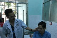 Bác sỹ thăm khám cho binh nhì Lê Hữu Thắng. (Ảnh: Đinh Hằng/TTXVN)