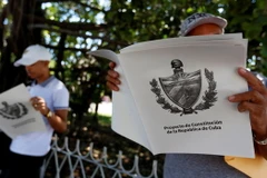 Người dân đọc chuyên san đăng tải Dự thảo Hiến pháp mới của Cuba tại La Habana. (Nguồn: EFE-EPA/TTXVN)