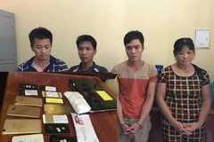 Các đối tượng trong đường dây đánh bạc và số tang vật thu được. (Ảnh: Khiếu Tư/TTXVN)