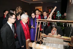 Tổng Bí thư Nguyễn Phú Trọng xem chế tác các sản phẩm tơ lụa của Tập đoàn Vạn Sự Lợi, thành phố Hàng Châu, tỉnh Chiết Giang. (Ảnh: Trí Dũng/TTXVN)