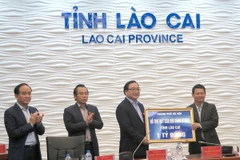 Bí thư Thành ủy Hà Nội Hoàng Trung Hải tặng quà và kinh phí hỗ trợ Quỹ xóa đói giảm nghèo tỉnh Lào Cai. (Ảnh: Hương Thu/TTXVN)