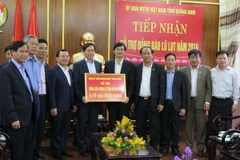 Đoàn công tác Đảng ủy Khối Doanh nghiệp Trung ương trao tượng trưng hơn 6,3 tỷ đồng cho lãnh đạo tỉnh Quảng Nam để giúp đỡ đồng bào vùng lũ lụt. (Ảnh: Đoàn Hữu Trung/TTXVN)