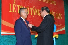 Ông Lê Hồng Anh, Ủy viên Bộ Chính trị, Thường trực Ban Bí thư gắn Huy hiệu 50 năm tuổi Đảng cho ông Trương Vĩnh Trọng. (Ảnh: Doãn Tấn/TTXVN)