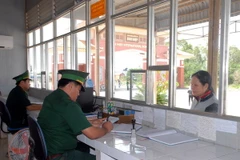 Bộ đội Biên phòng cửa khẩu quốc tế Bình Hiệp (Long An) làm thủ tục xuất nhập cảnh cho du khách. (Ảnh: Mạnh Linh/TTXVN)
