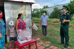 Thượng tá Doãn Đình Tránh, Phó Chính ủy Bộ Chỉ huy Bộ đội Biên phòng Kiên Giang, đến thăm, tặng quà bà con vùng biên giới. (Ảnh: TTXVN phát)