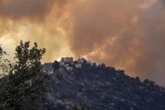 Khói lửa bốc lên trong vụ cháy rừng ở vùng Kabylie thuộc Algeria. (Ảnh: AFP/TTXVN)