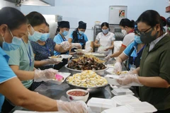 Các tình nguyện viên nấu nhưng suất cơm 0 đồng để cung cấp cho các khu cách ly. (Ảnh: Thanh Thủy/TTXVN)