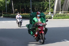 Dịch vụ giao hàng tận nhà nở rộ trong mùa dịch. (Ảnh: Tiến Lực/TTXVN)