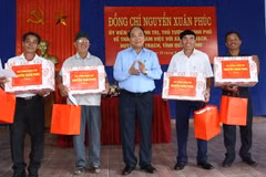 Thủ tướng Nguyễn Xuân Phúc tặng quà cho các thôn của xã Đức Trạch, huyện Bố Trạch. (Ảnh: Thống Nhất/TTXVN)