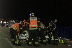 Nhân viên cứu hộ đưa nạn nhân lên cáng tại hiện trường. (Nguồn: AFP)