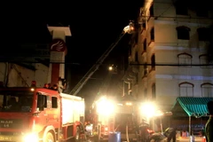 Cảnh sát Phòng cháy chữa cháy phun nước vào tầng 5 Công ty Kwong Lung-Meko để dập lửa. (Ảnh: Thanh Liêm/TTXVN)