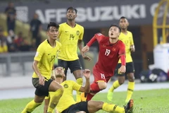 Quang Hải (áo đỏ) chính là cầu thủ xuất sắc nhất AFF Suzuki Cup 2018. (Ảnh: Hoàng Linh/TTXVN)