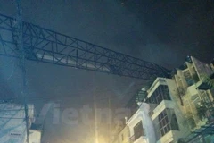 Cần cẩu dài hàng chục mét đổ sang nóc ngôi nhà số 80. (Ảnh: Sơn Bách/Vietnam+)