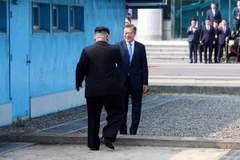 Tổng thống Hàn Quốc Moon Jae-in đón Nhà lãnh đạo Triều Tiên Kim Jong-un (trái) tại đường phân định ranh giới hai miền ở làng đình chiến Panmunjom. (Nguồn: YONHAP/TTXVN)