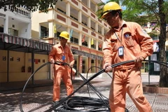 Công nhân của EVN HANOI kéo bổ sung nguồn điện lưới. (Ảnh Mạnh Khánh/TTXVN)