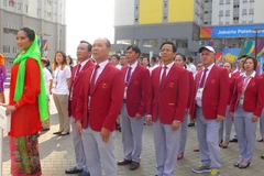 Các thành viên đoàn Việt Nam hát quốc ca khi lá cờ Việt Nam được kéo lên. (Nguồn: Vietnam+)