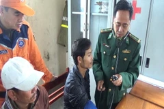 Quân y sỹ đồn Biên phòng Roòn chăm sóc sức khỏe cho thuyên viên gặp nạn. (Ảnh: Đức Thọ/TTXVN)
