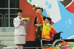 Võ Thanh Tùng (áo vàng) nhận huy chương bạc Asian Para Games 2018. (Ảnh: Hải Ngọc/TTXVN)