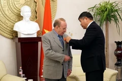 Thừa ủy quyền của Chủ tịch nước Trần Đại Quang, Đại sứ Đoàn Xuân Hưng trao tặng Huân chương Hữu nghị cho ông Hellmut Kapfenberger. (Ảnh: Phạm Văn Thắng/TTXVN)