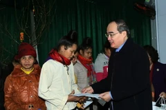 Chủ tịch Uỷ ban Trung ương MTTQ Việt Nam Nguyễn Thiện Nhân tặng quà Tết cho gia đình nghèo ở bản tái định cư. (Ảnh: Nguyễn Dân/TTXVN)